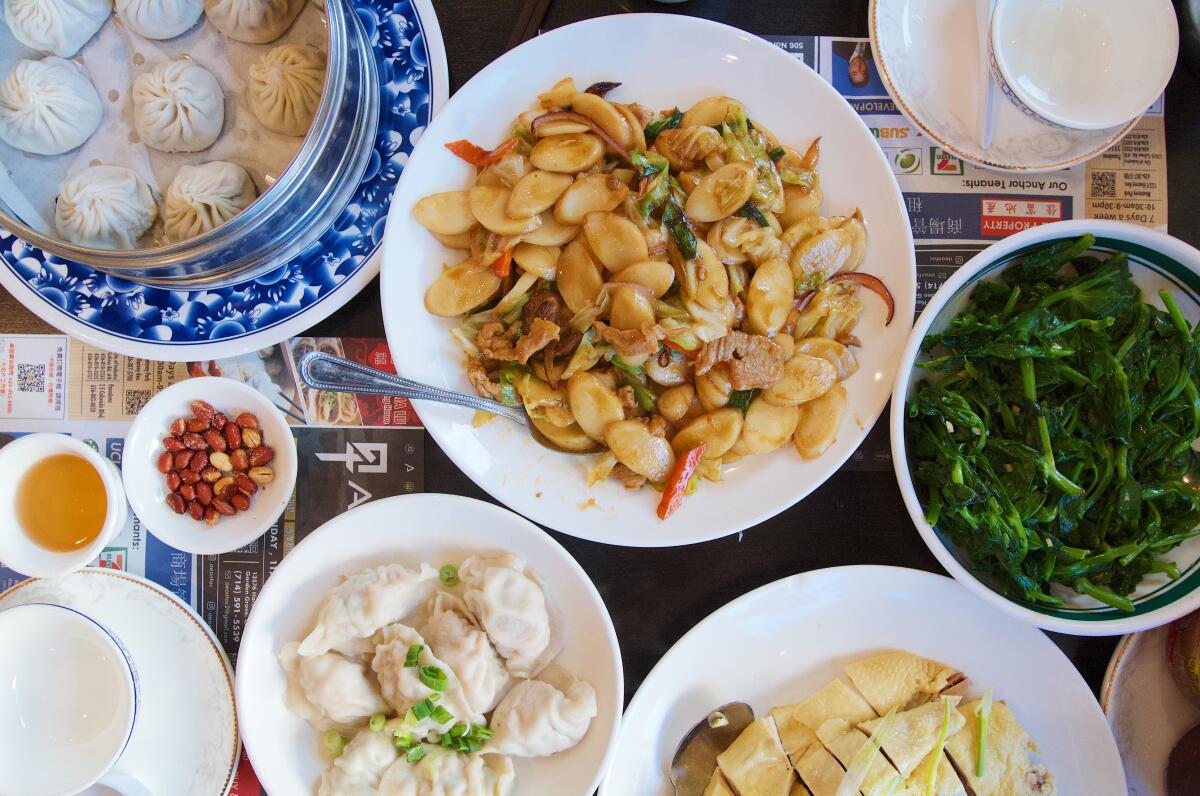 An overhead photo of a spread from Mama Lu Dumpling House including soup dumpling, rice cake stir fry and chicken.