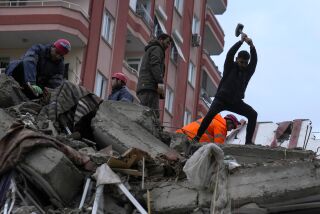 Rescatistas buscan a personas desaparecidas en un edificio que se desplomó tras un terremoto, el lunes 6 de febrero de 2023, en Adana, Turquía. (AP Foto/Khalil Hamra)