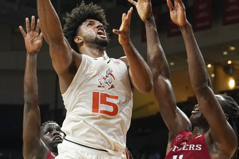 Miami's forward Norchad Omier (15) drives to the basket over Rutgers' center Clifford Omoruyi (11) during the first half of an NCAA college basketball game, Wednesday, Nov. 30, 2022, in Coral Gables, Fla. (AP Photo/Marta Lavandier)