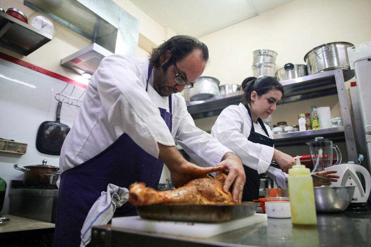 Chef Fadi Kattan, left, and Fateen Halahla prepare dishes at Fawda.