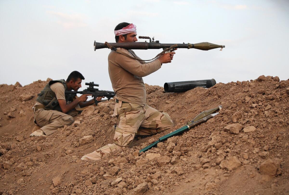 Kurdish fighters guard a position on the front lines east of Mosul, Iraq.