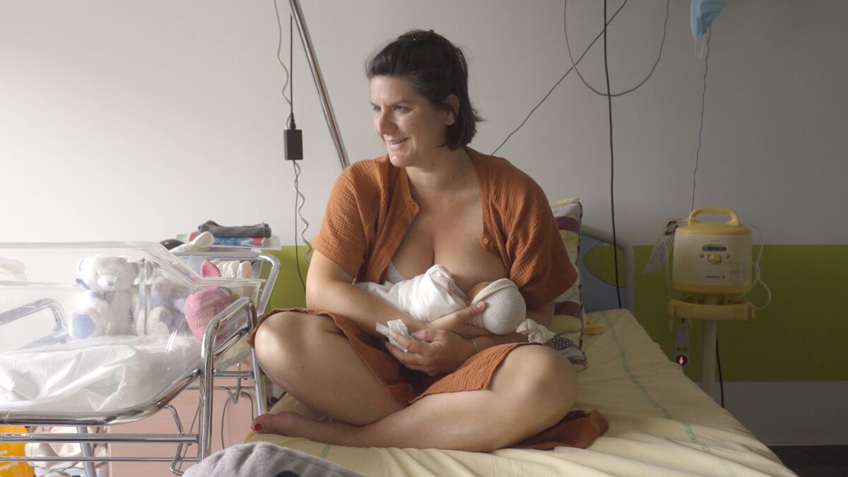 A woman breastfeeds her child in the documentary "Our Body."