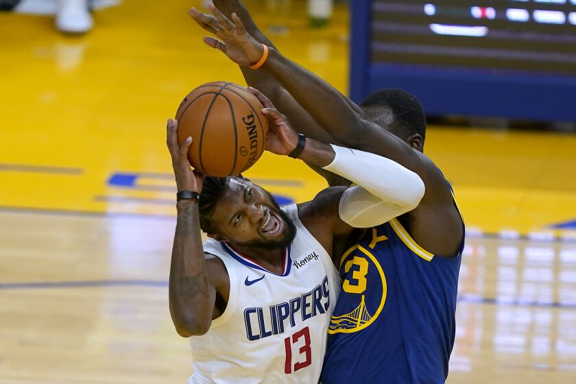 Los Angeles Clippers guard Paul George (13) reacts as he is fouled by Golden State Warriors forward Draymond Green (23) during the first half of an NBA basketball game in San Francisco, Friday, Jan. 8, 2021. (AP Photo/Tony Avelar)