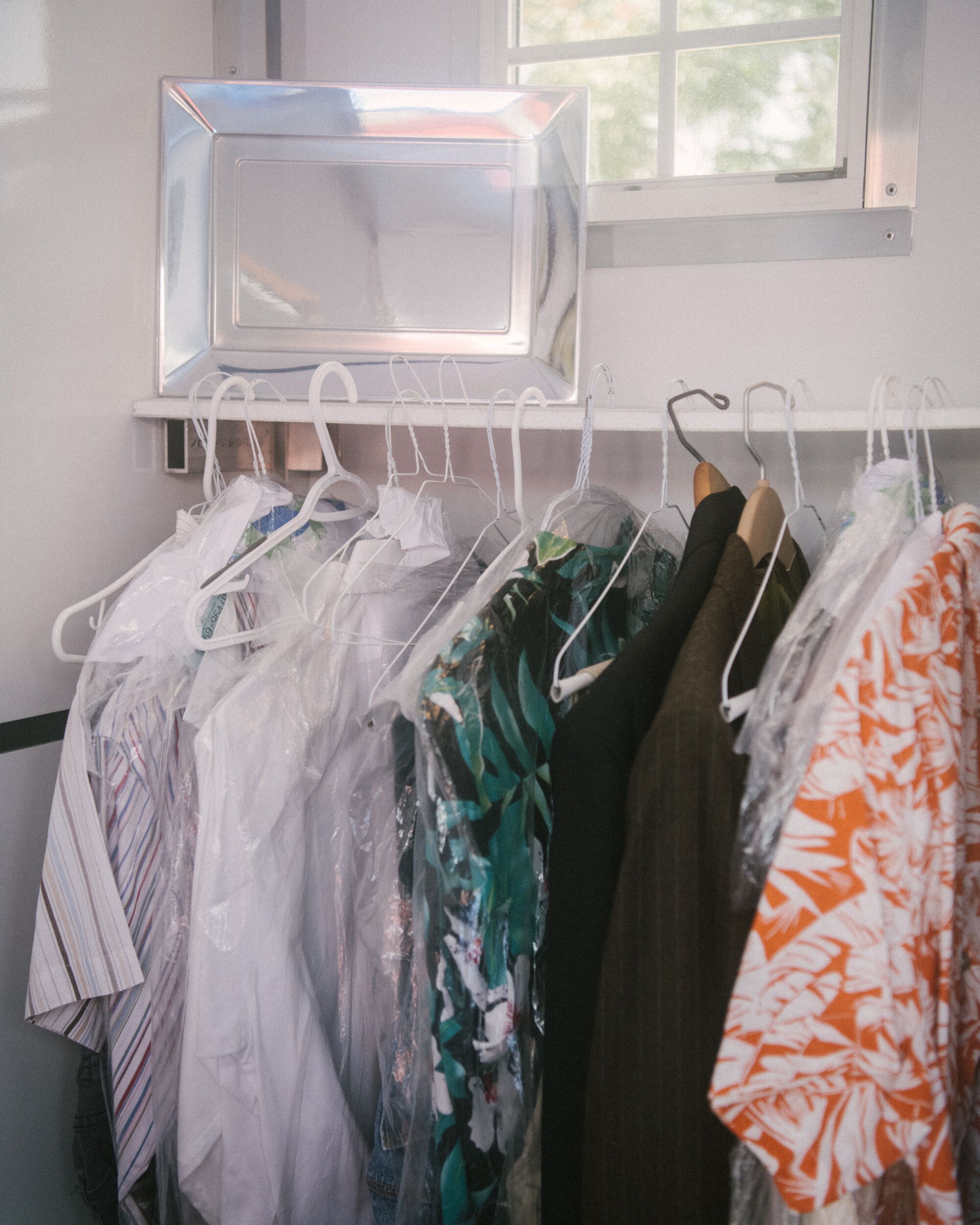 Clothes are neatly organized on hangers.