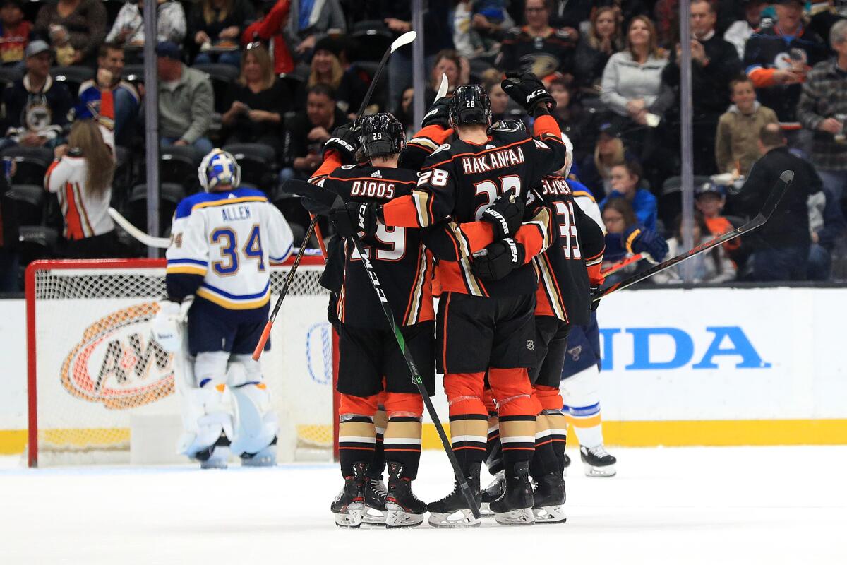 Ducks' Christian Djoos (29) and Jakob Silfverberg (33) congratulate Jani Hakanpaa (28) after he scored his first NHL goal during the second period at Honda Center on March 11.