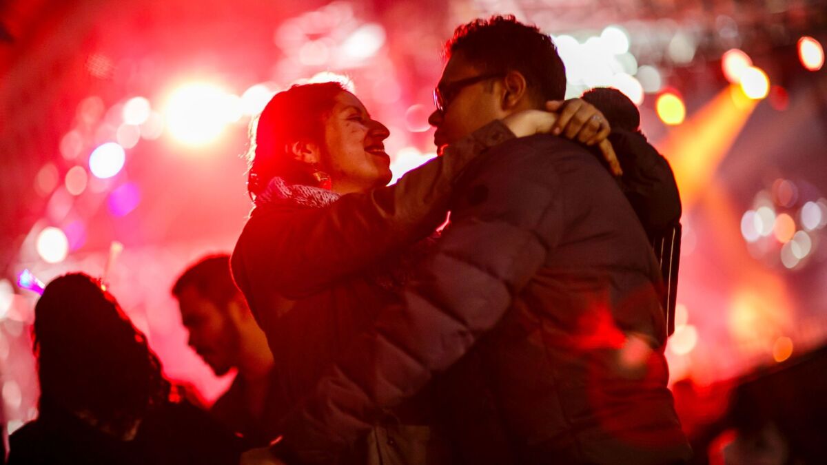 Jessica Rodrigues and Cornelius Rodrigues embrace each other while dancing at the New Year's Eve celebration in Grand Park.