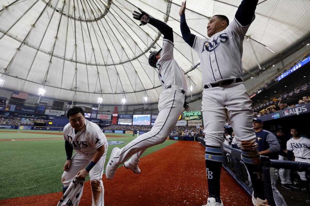 Tampa Bay's Willy Adames, left, celebrates with teammate Avisail Garcia after hitting a solo home run.