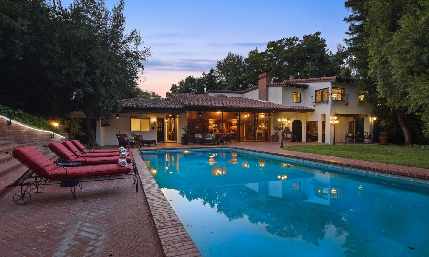 The half-acre property holds four residences, a swimming pool, gym and lawn lined with lampposts.
