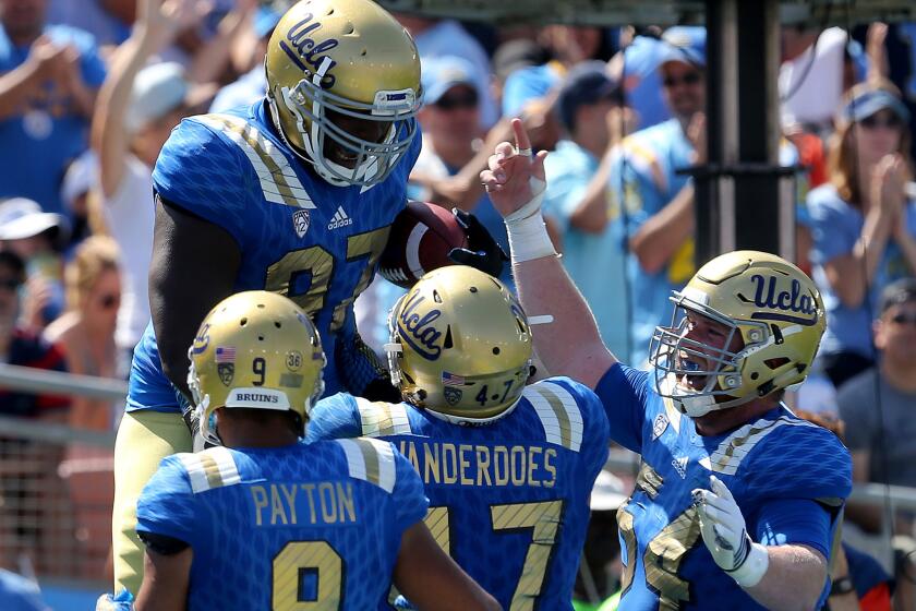 UCLA defensive lineman Kenny Clark (97) is congratulated by teammates after scoring a touchdown on a pass play against Virginia in the second half on Sept. 5.