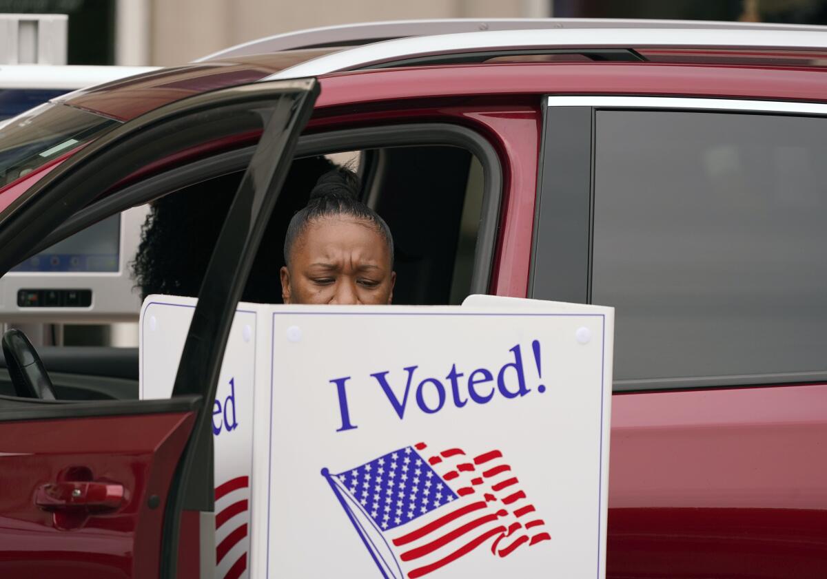 A voter makes her choices from a vehicle outside the American Airlines Center in Dallas.