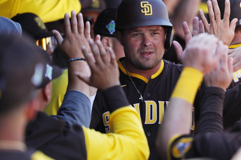 PEORIA, AZ - MARCH 21: San Diego Padres' Luke Voit celebrates with teammates after scoring in the first inning of a spring training game against the Colorado Rockies on Monday, March 21, 2022 in Peoria, AZ. (K.C. Alfred / The San Diego Union-Tribune)