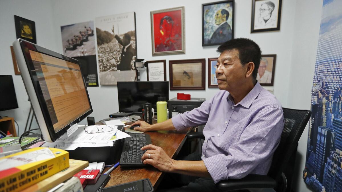 Dinh Quang Anh-Thai, senior editor and assistant to the publisher, searches through daily news articles in his office at the Nguoi Viet Daily News in Westminster.