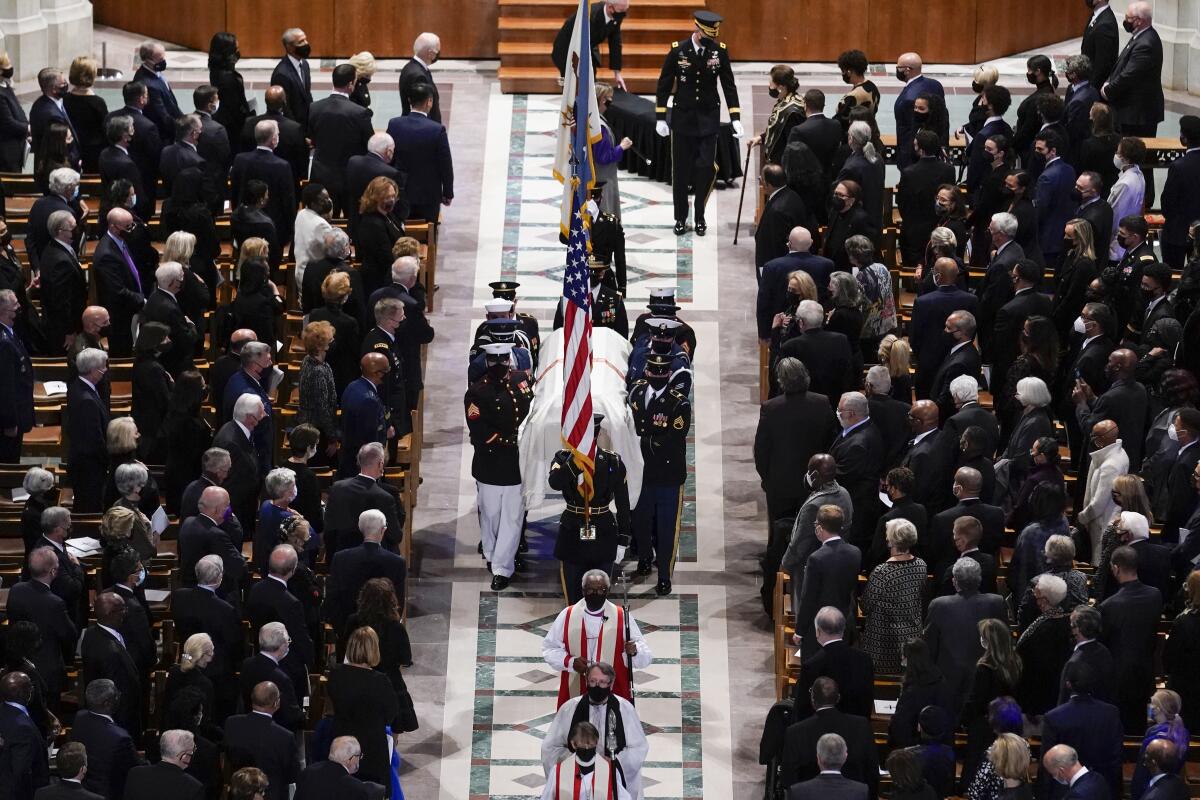 A military honor guard carries the casket of Colin Powell out of the National Cathedral after his funeral