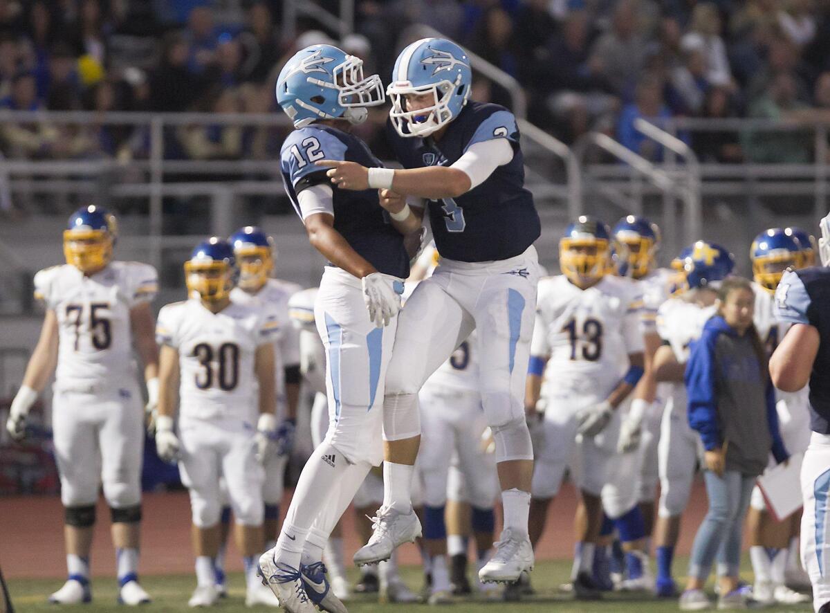 Corona del Mar High receiver Taeveon Le, left, and quarterback Chase Garbers celebrate a touchdown against El Toro on Friday. Le had nine catches for 231 yards and three touchdowns.