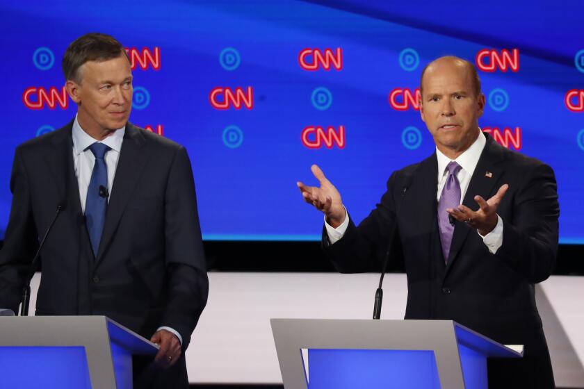 Former Colorado Gov. John Hickenlooper watches as former Maryland Rep. John Delaney speaks during the first of two Democratic presidential primary debates hosted by CNN Tuesday, July 30, 2019, in the Fox Theatre in Detroit. (AP Photo/Paul Sancya)