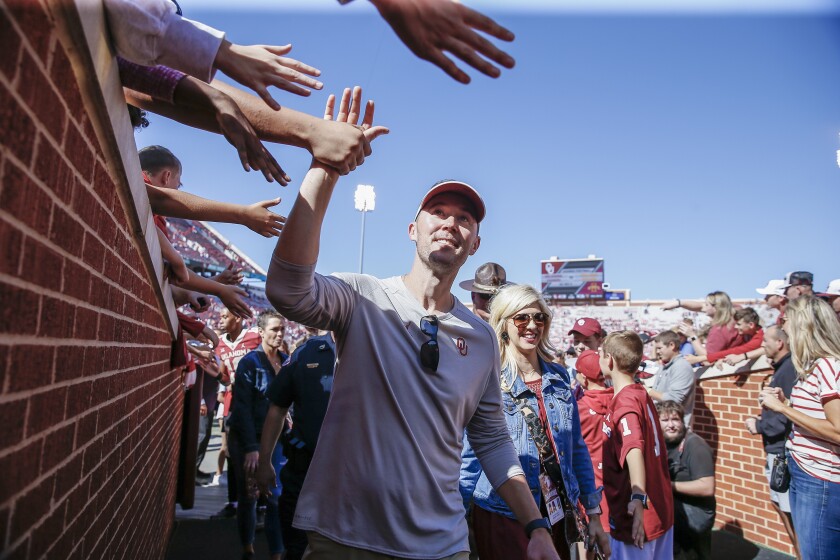 Oklahoma coach Lincoln Riley high-fives fans following a 2019 win over West Virginia