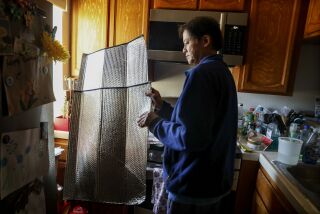 SAN DIEGO, CA-JAN 19: Soo Hom places a car shield in his window to keep heat out at his home in University City on Thursday, January 19, 2023. Hom doesn't use SDG&E gas to heat his home. He only uses the hot water and, sometimes, the stove. He uses car sun shields on his windows as insulation at night, to keep the cold air out. (Sandy Huffaker for The San Diego Union Tribune)