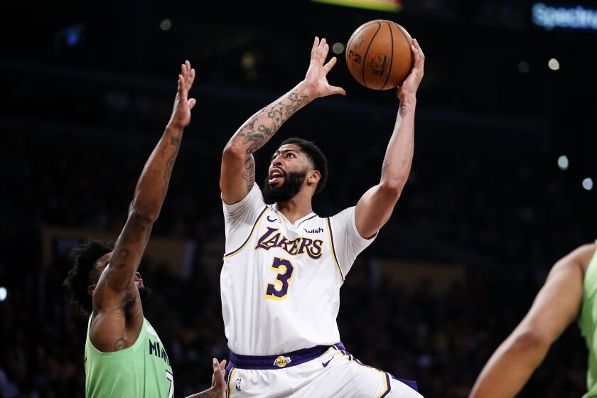Los Angeles Lakers' Anthony Davis (3) shoots against Minnesota Timberwolves' Jordan Bell (7) during the first half of an NBA basketball game, Sunday, Dec. 8, 2019, in Los Angeles. (AP Photo/Ringo H.W. Chiu)