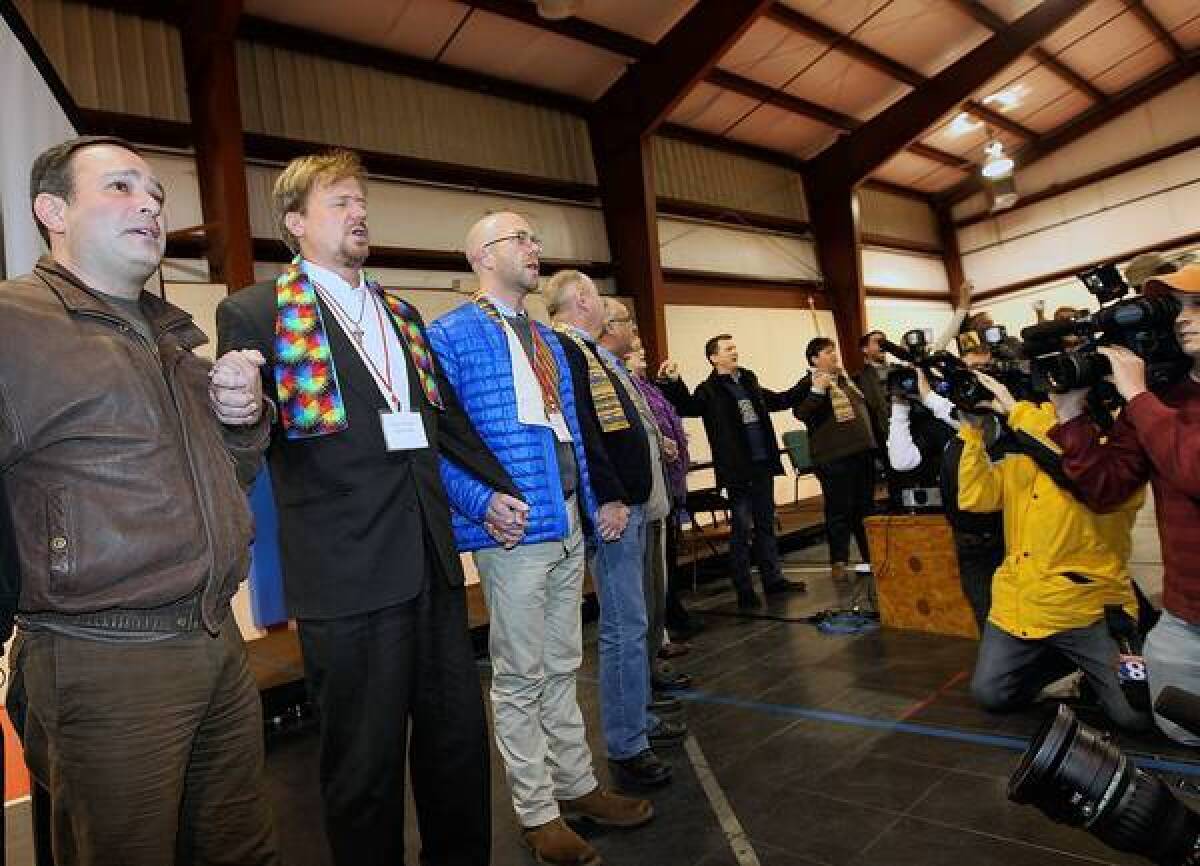 The Rev. Frank Schaefer, second from left, sings hymns with supporters after his church trial in Pennsylvania. He was found to have broken United Methodist Church law for performing the marriage of his gay son, and was given a 30-day suspension.