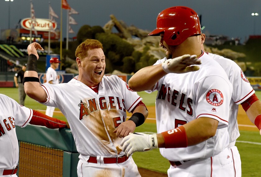 Albert Pujols, right, gets a high-five from Kole Calhoun after hitting solo home run on Aug. 29.