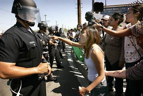Los Angeles Police Department officers keep protesters out of a South Los Angeles' urban farm.