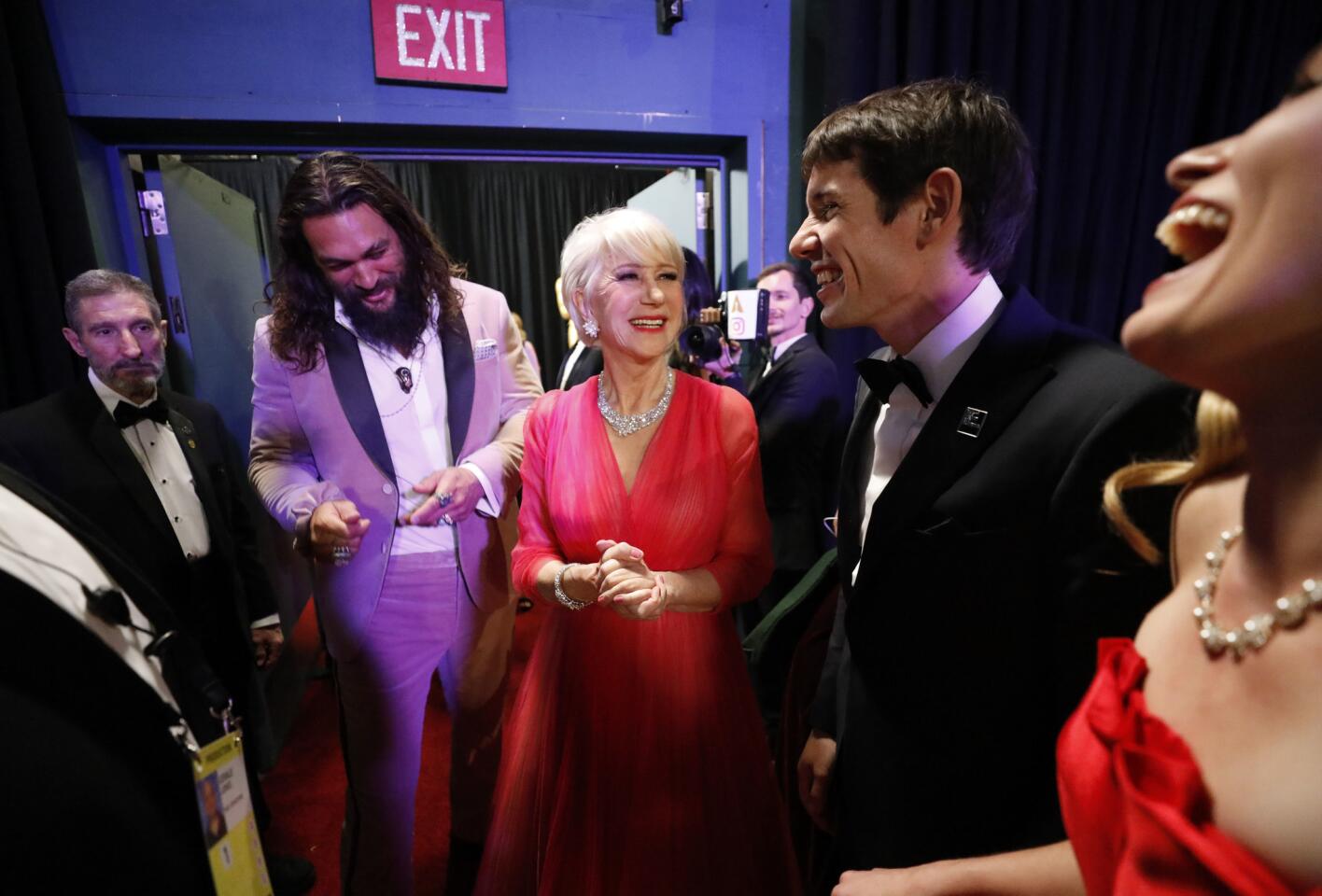 Presenters Jason Momoa and Helen Mirren chat with Alex Honnold, subject of the winning documentary feature, "Free Solo," backstage at the Oscars.