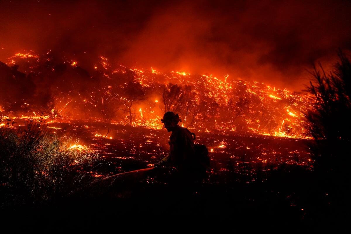 The Bond fire began when a structure fire spread into nearby vegetation, according to the Orange County Fire Authority.