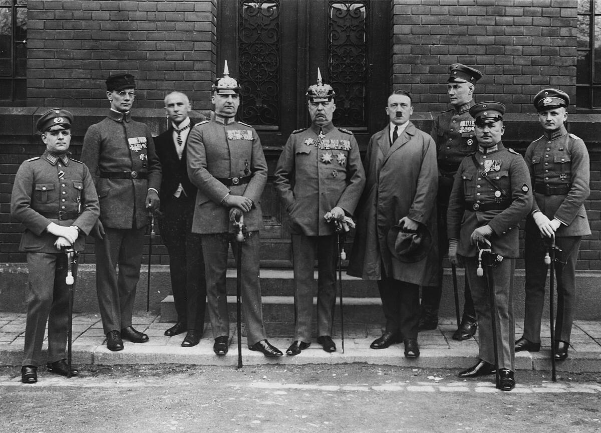 A black and white photo from the 1930s of men in military uniforms standing with Adolf Hitler