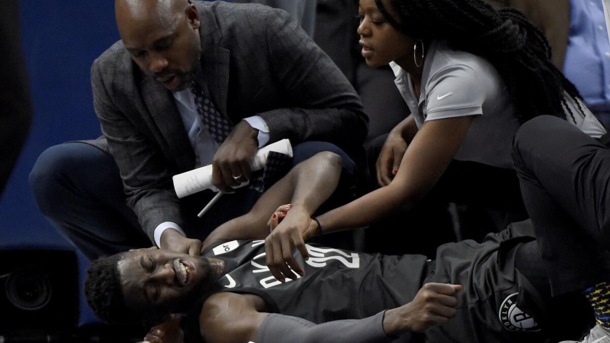Brooklyn Nets guard Caris LeVert (22) is tended to after an injury.