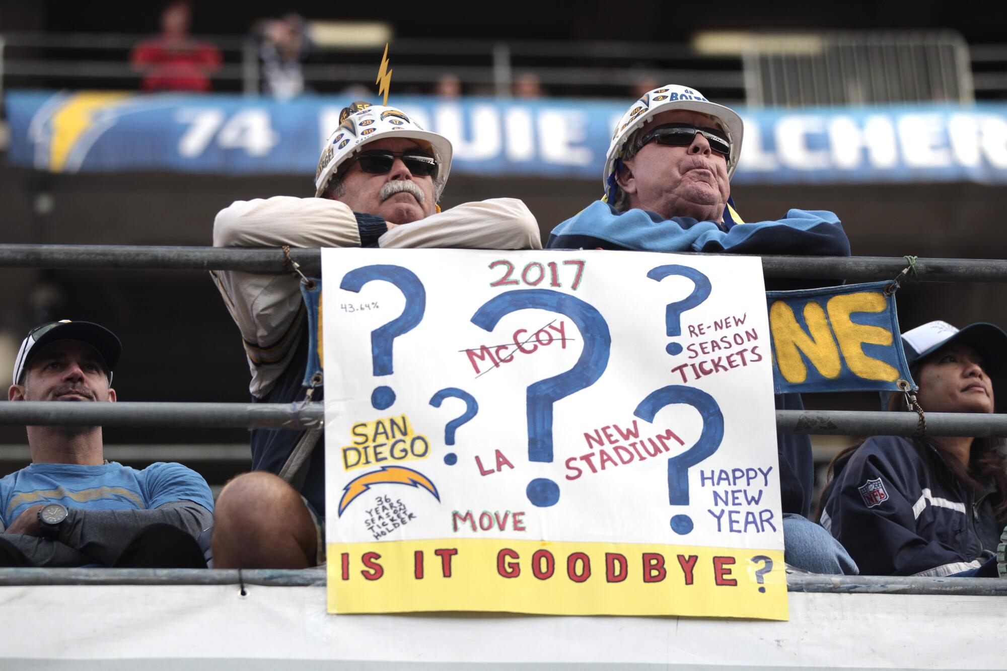 Two Chargers fans sit behind their sign during the second half of the Chargers vs. Kansas City game at Qualcomm Stadium.