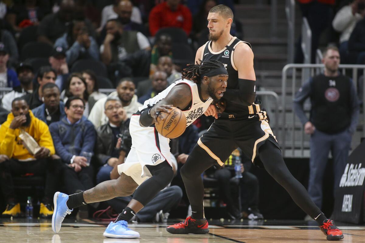 Clippers center Montrezl Harrell tries to drive past Hawks center Alex Len during the first half of a game Jan. 22, 2020, in Atlanta.