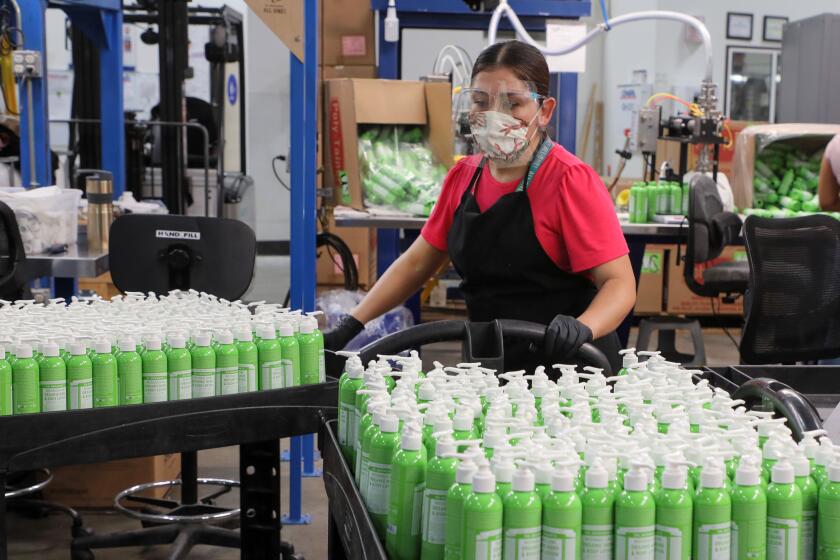 October 22, 2020, Vista, California_USA_| At Dr. BronnerOs All-One! employee Judith Ramirez moves carts of just-filled bottles of the companyOs body lotion. _Photo Credit: Photo by Charlie Neuman