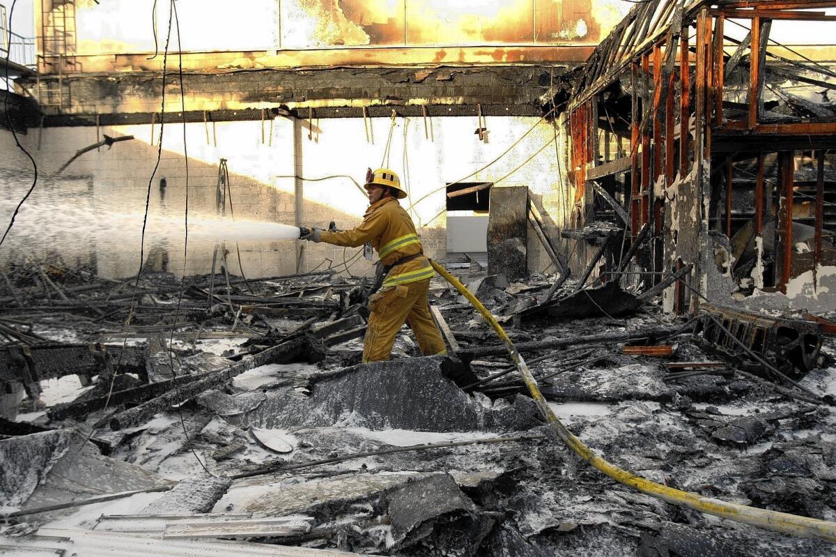 A Los Angeles firefighter battles a car dealership blaze in January. The department hasn't hired a new firefighter in five years, a union official says, leaving fewer firefighters to handle a growing workload.