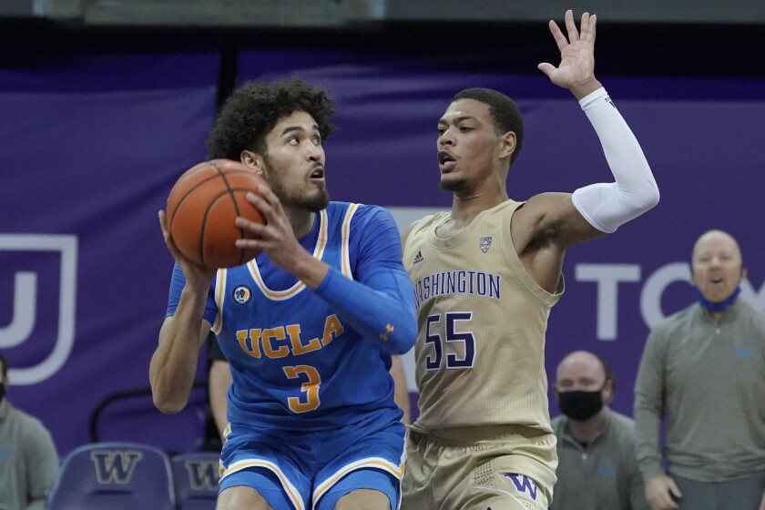 UCLA's Johnny Juzang looks to shoot as Washington's Quade Green defends during the second half Feb. 13, 2021, in Seattle.