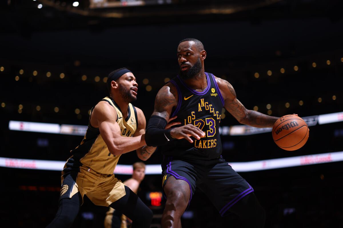Lakers forward LeBron James protects the ball from Raptors forward Bruce Brown during their game Tuesday night at Toronto.