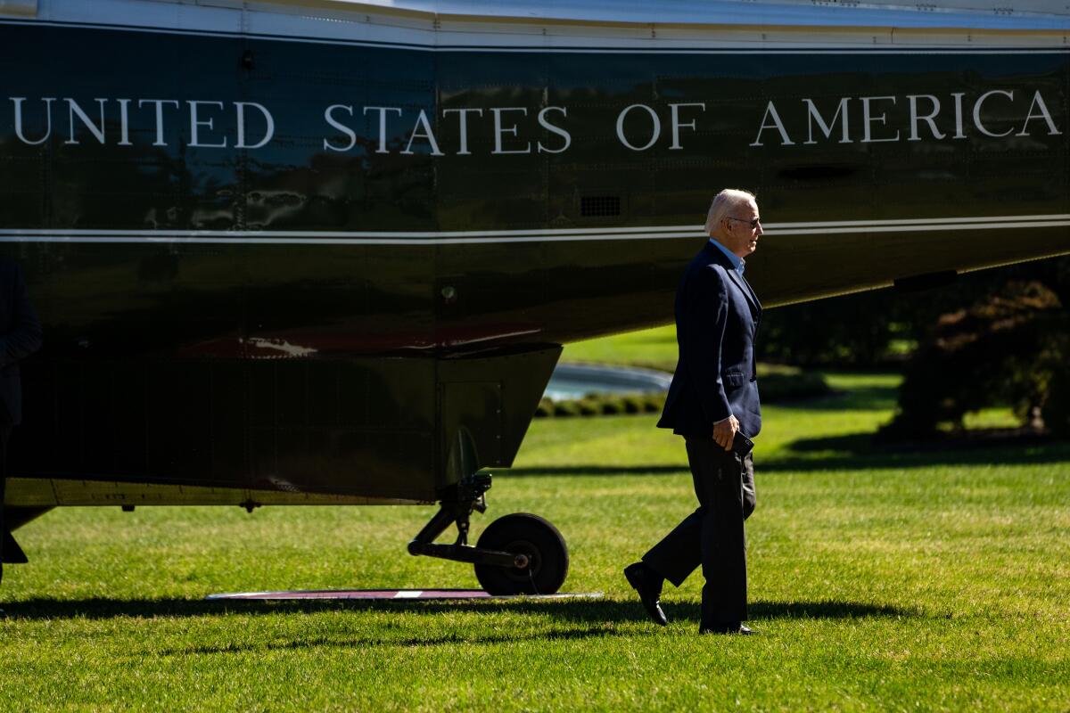 President Biden walks past a helicopter on the South Lawn of the White House