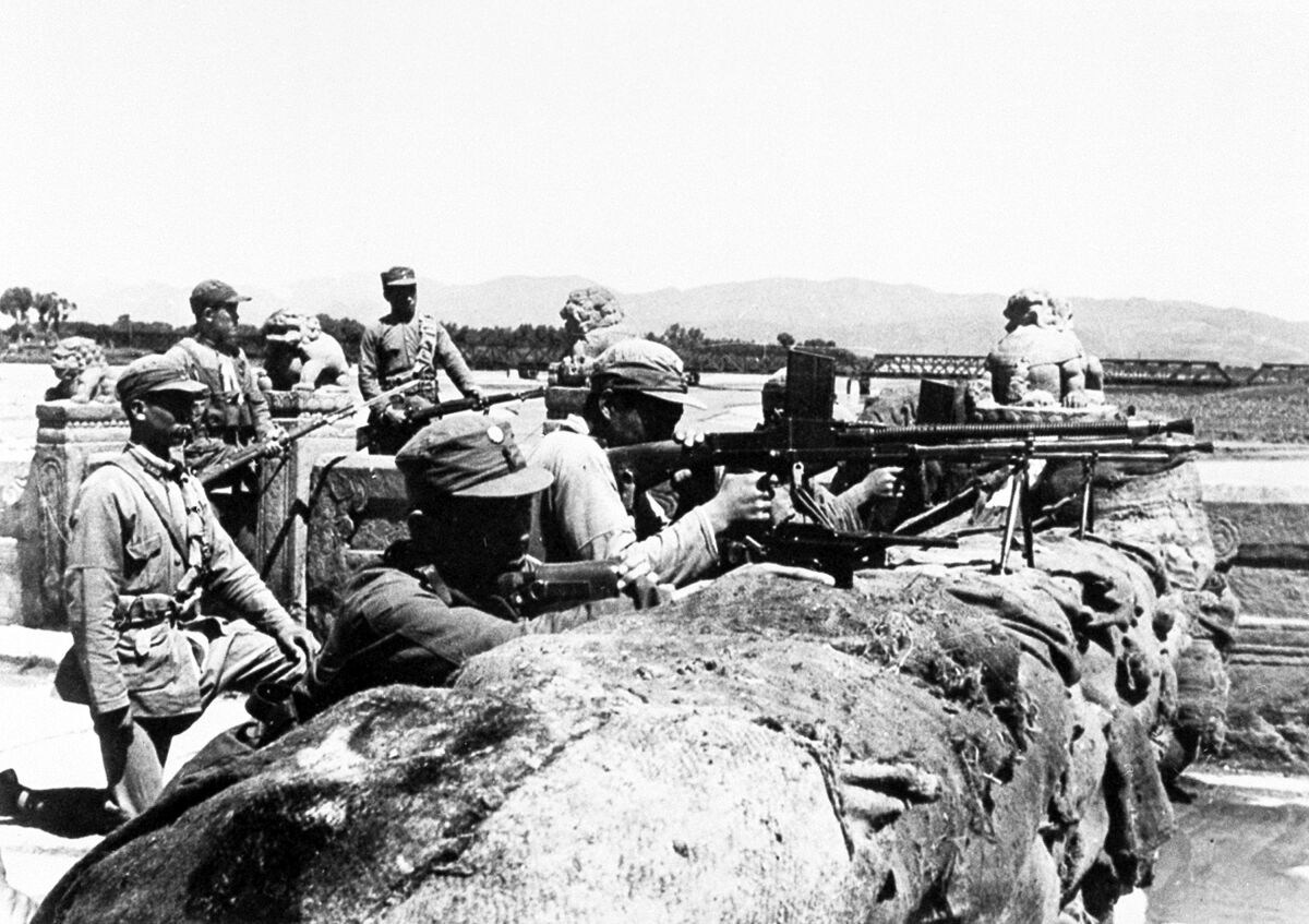 FILE - In this July 8, 1937, file photo, members of the Chinese 29th Army defend the city behind a hastily constructed sandbag barricade on the Marco Polo Bridge, 14 miles (22.5 kilometer) southwest of Pieping, China, against Japanese attackers. On July 7, Chinese troops fired on Japanese troops at the Marco Polo bridge, a clash between the two countries that led to the Second Sino Japanese War. The Pacific War was so massive and so calamitous that it can be difficult to put it in context. There was the Marco Polo Bridge Incident that triggered the Sino-Japanese War, the Battle of Midway that changed the course of the war and the dramatic flag-raising on Iwo Jima. (AP Photo/File)