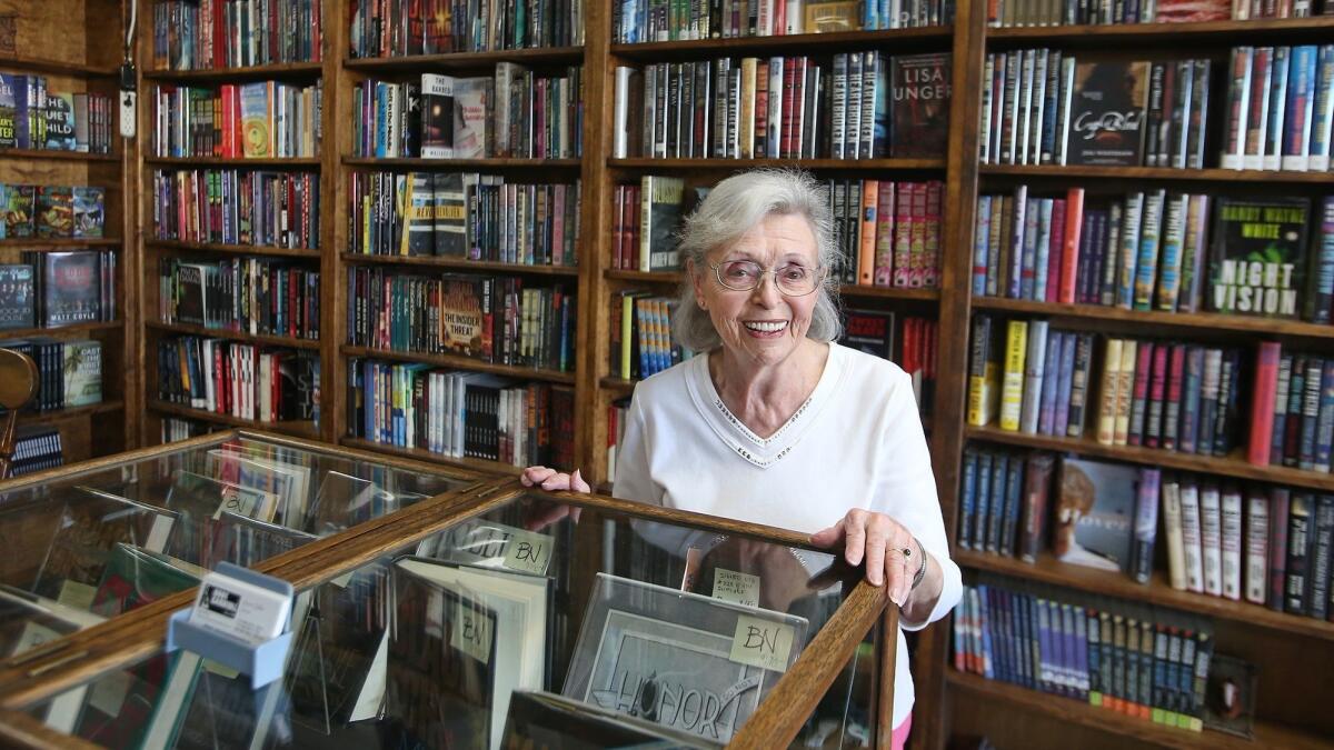 Owner Anne Saller stands in the front room of Book Carnival in Orange, where she hosts a book club and offers a variety of used books. .