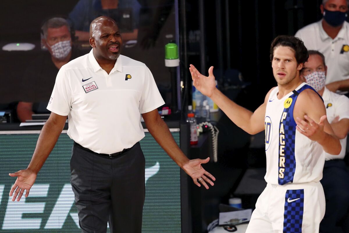 Indiana Pacers head coach Nate McMillan and forward Doug McDermott (20) react to a call during the second half of an NBA basketball game against the Miami Heat, Monday, Aug. 10, 2020, in Lake Buena Vista, Fla. (Kim Klement/Pool Photo via AP)