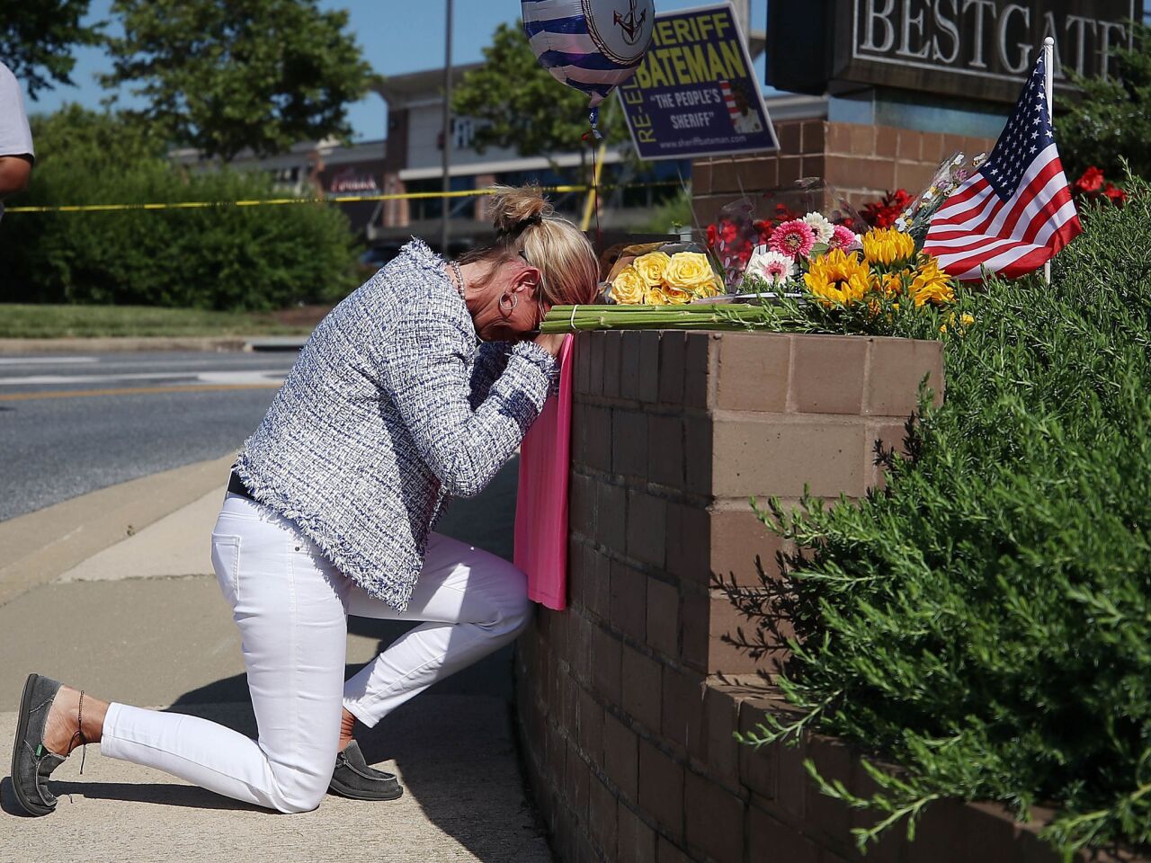 Lynne Griffin pays her respects at a makeshift memorial near the Capital newspaper offices, where five people were shot and killed Thursday in Annapolis, Md. Griffin was a journalism student under John McNamara, who was one of the people killed at the paper.