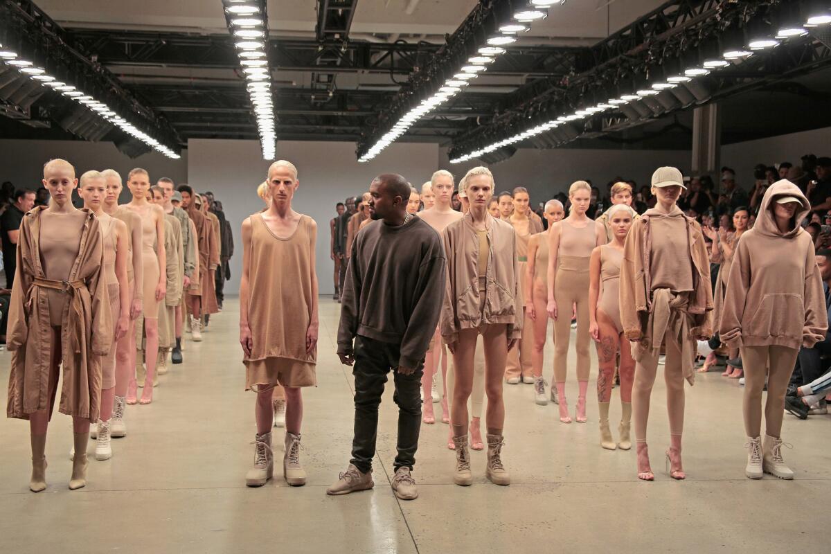 Kanye West poses among the models during the finale of the show for the Kanye West Yeezy collection at Skylight Modern on Sept. 16 during New York Fashion Week.