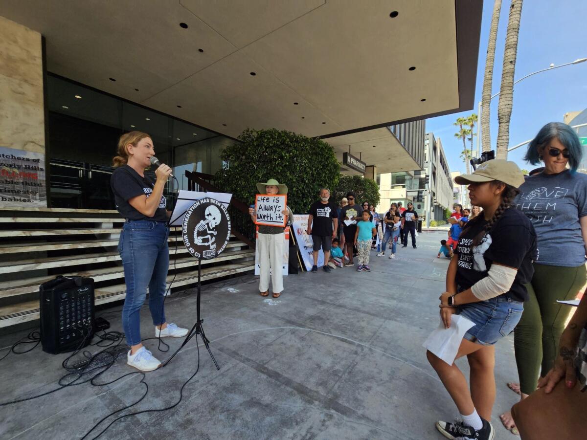 A woman with a microphone addresses fellow antiabortion activists.