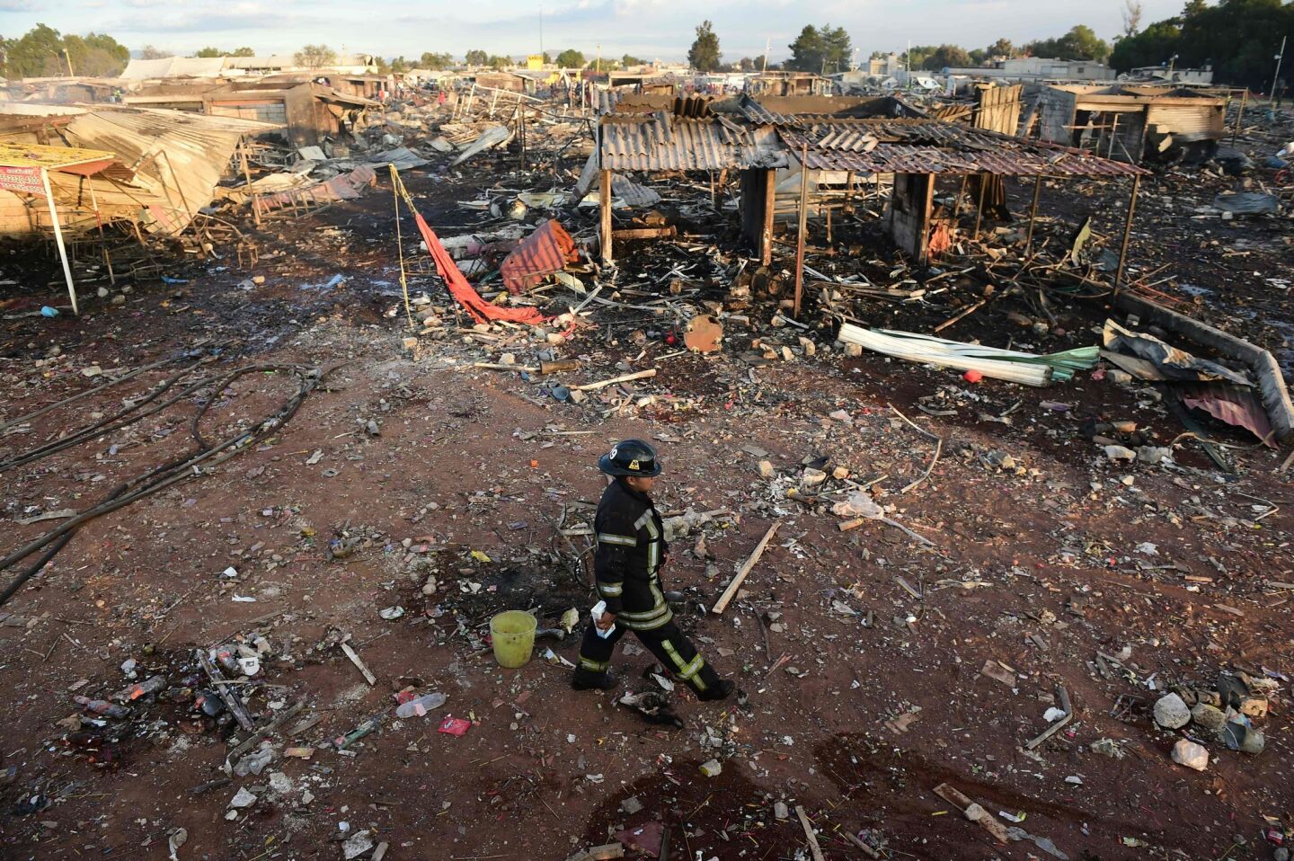 Firefighters work amid the debris left by a huge blast at a fireworks market in Tultepec, Mexico.