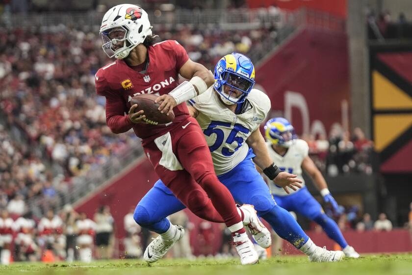  Cardinals quarterback Kyler Murray (1) leaves the pocket under pressure Rams defensive tackle Braden Fiske (55).