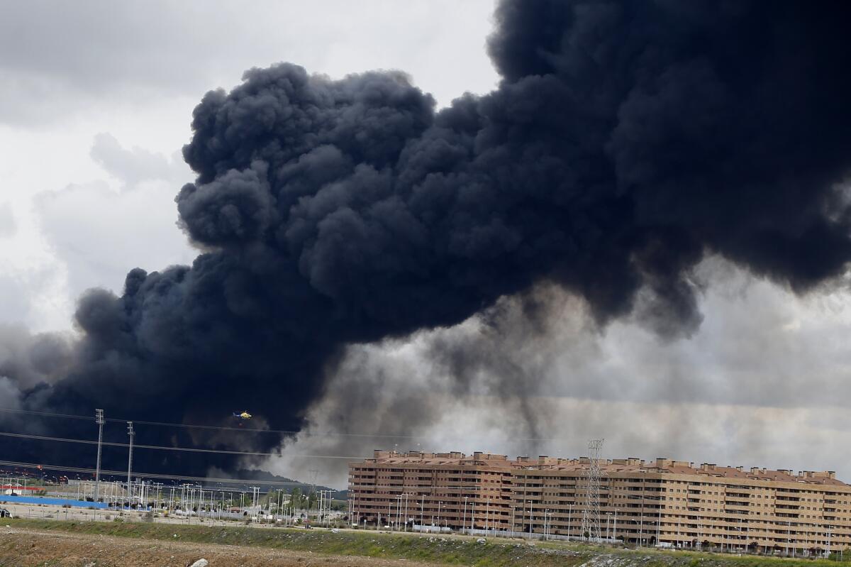 Black smoke from a massive tire fire rises from behind housing blocks in Sesena, Spain, on May 13.