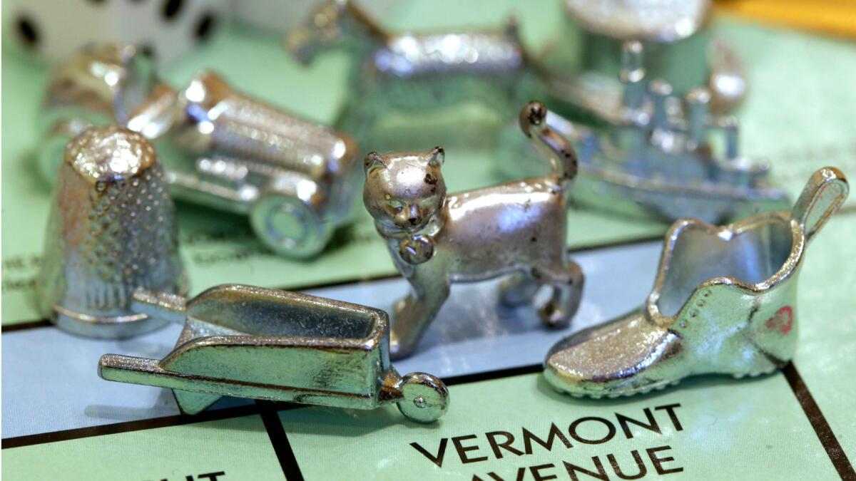 The thimble game piece, left, sits among other Monopoly tokens at Hasbro Inc., headquarters in Pawtucket, R.I.