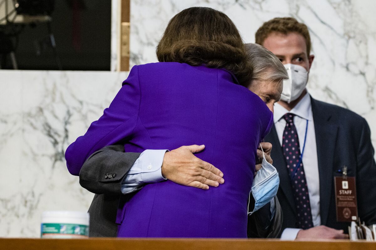 Senators Lindsey Graham and Dianne Feinstein hug in a Senate hearing room