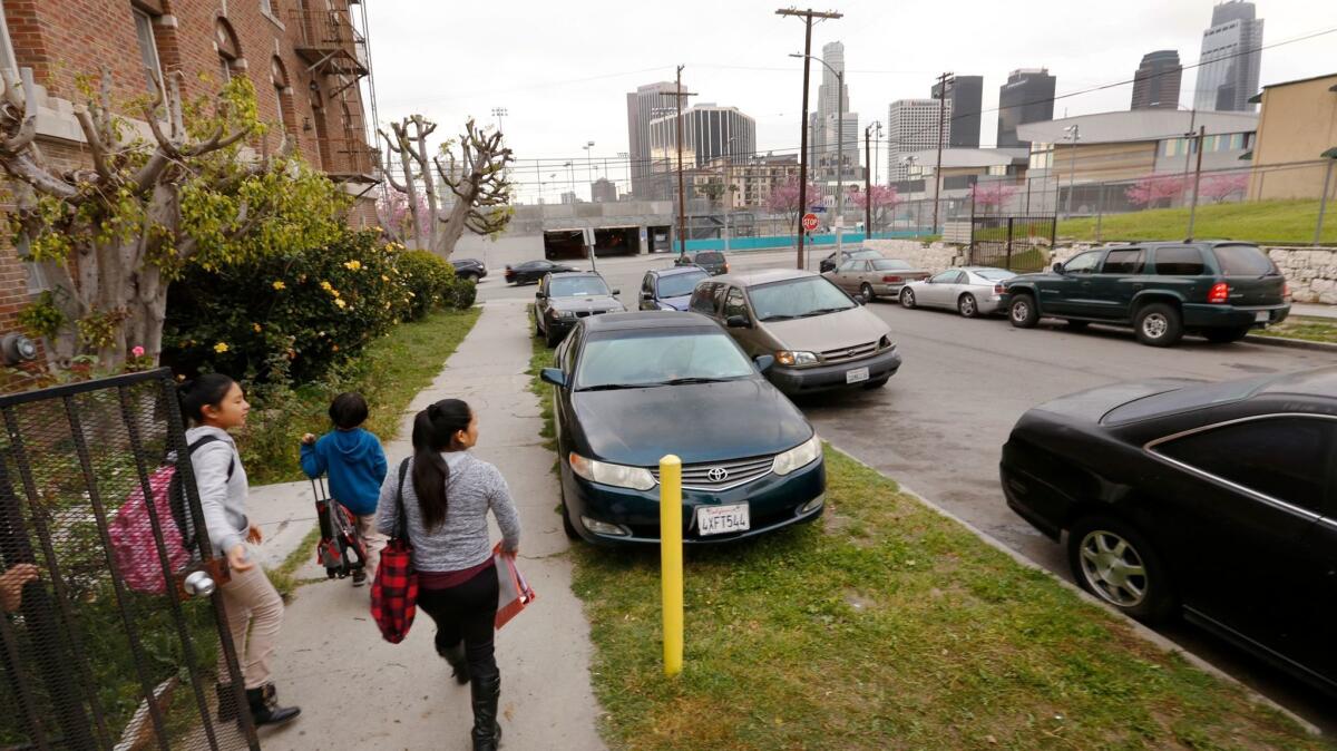 Children leave for school on Miramar Street near Lucas Avenue in Westlake. Residents are complaining that cars parked in parkways are an eyesore and are destroying the grass and landscaping.