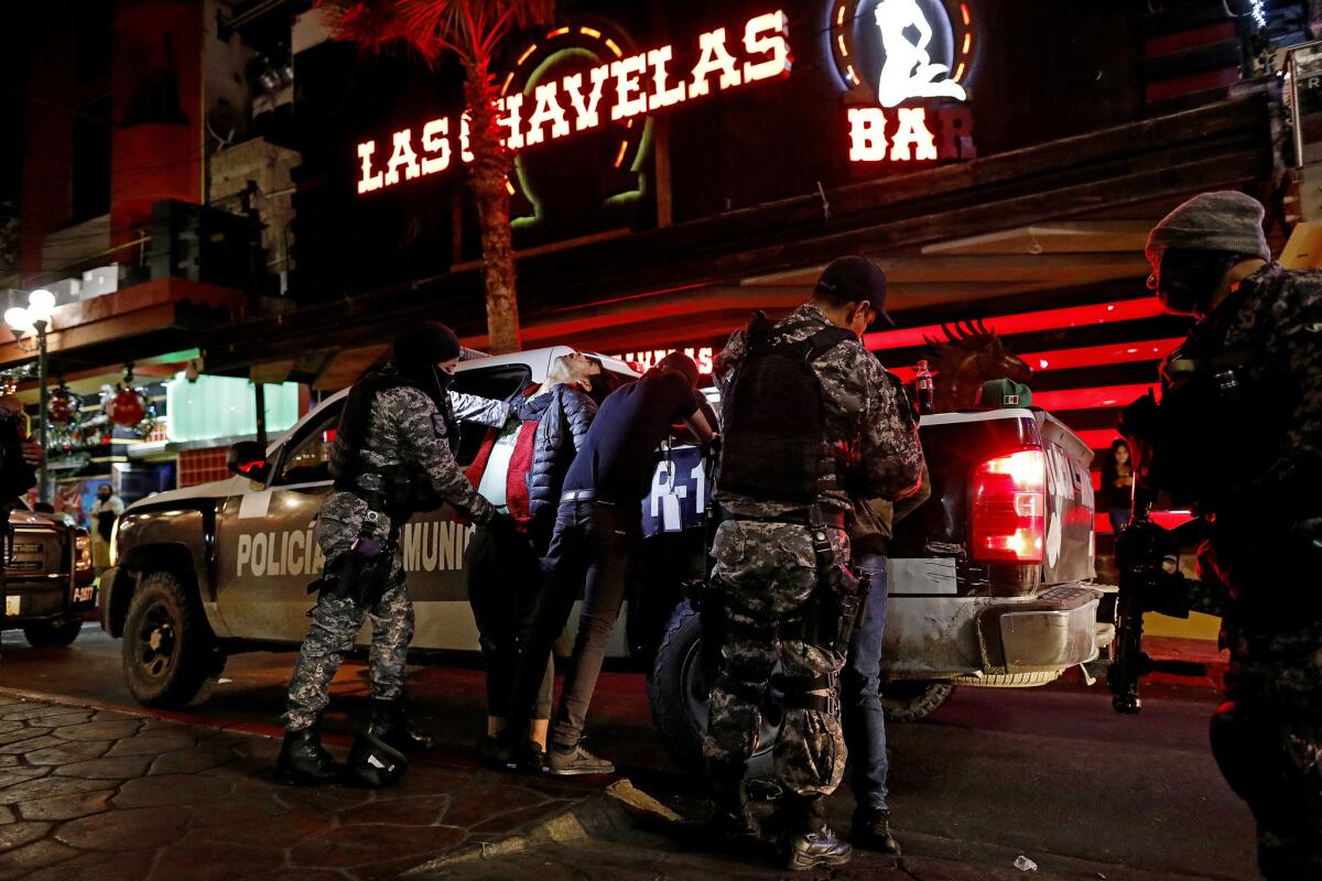 A specialized Tijuana City police unit frisks people for drugs and firearms along Calle Coahuila in the rough red-light district of colonia Zona Norte.