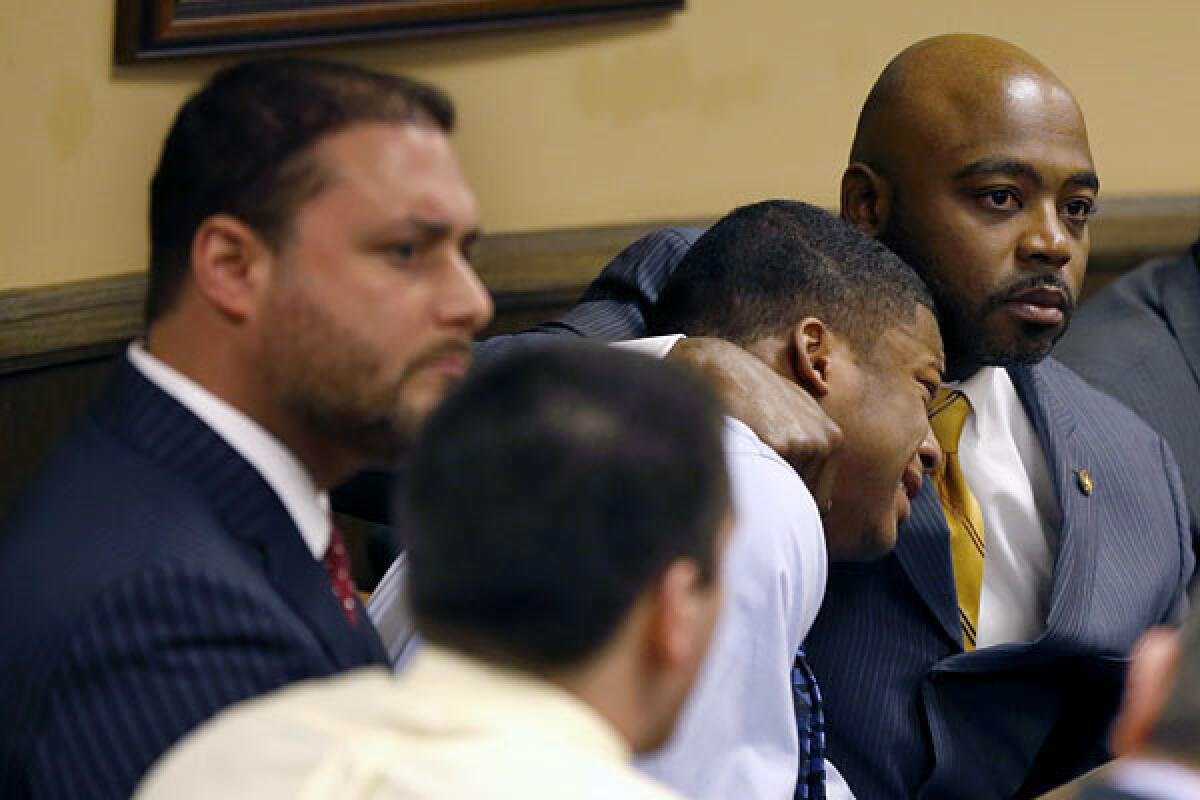 Defense attorney Walter Madison holds his client, 16-year-old Ma'Lik Richmond while Trent Mays, 17, sits in the foreground as Judge Thomas Lipps pronounces both defendants guilty of delinquent on rape and other charges.